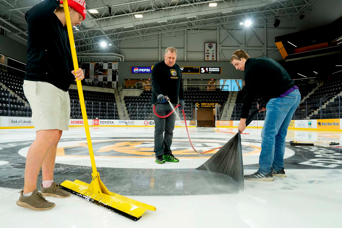 Alexander Coffee, left, Don Moffatt, center, both Head Ice Technicians, and intern JD Dixon, remove ice and decals on May 8 at Robson Arena after hockey season’s end and to prepare the building for commencement, as well as other summer activities. Photo by Jamie Cotten / Colorado College