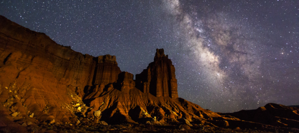 Photo of rock formations against a starry sky (Milky Way).