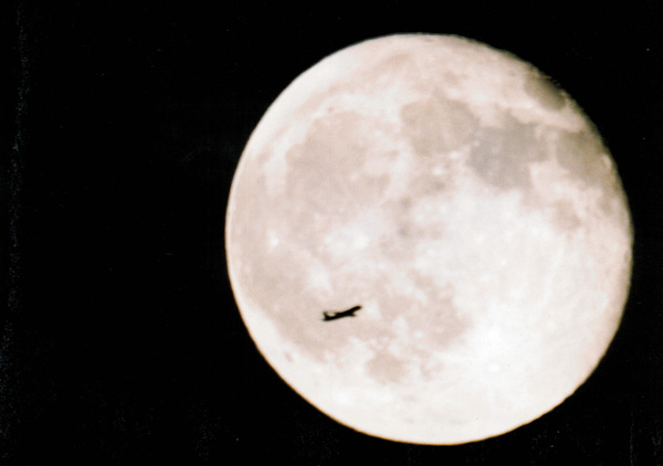 Photo of the moon with jet flying in front of it