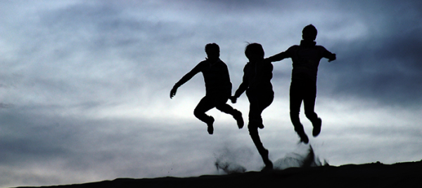 Photo of the silhouette of three people jumping