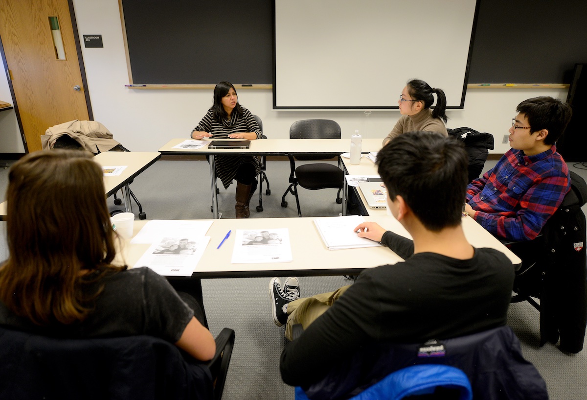 Students and a professor discussing around a table