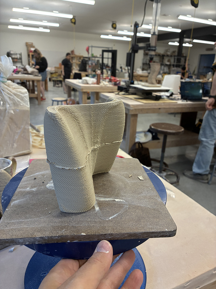 A digitally printed ceramic sculpture on a turn table in a clay studio