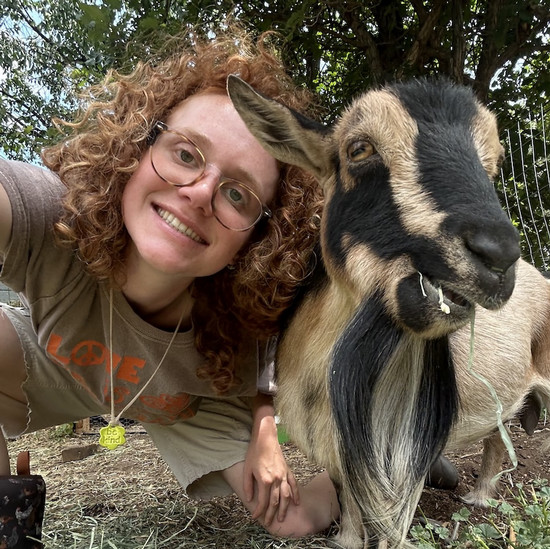 photo of female student taking a selfie with a goat