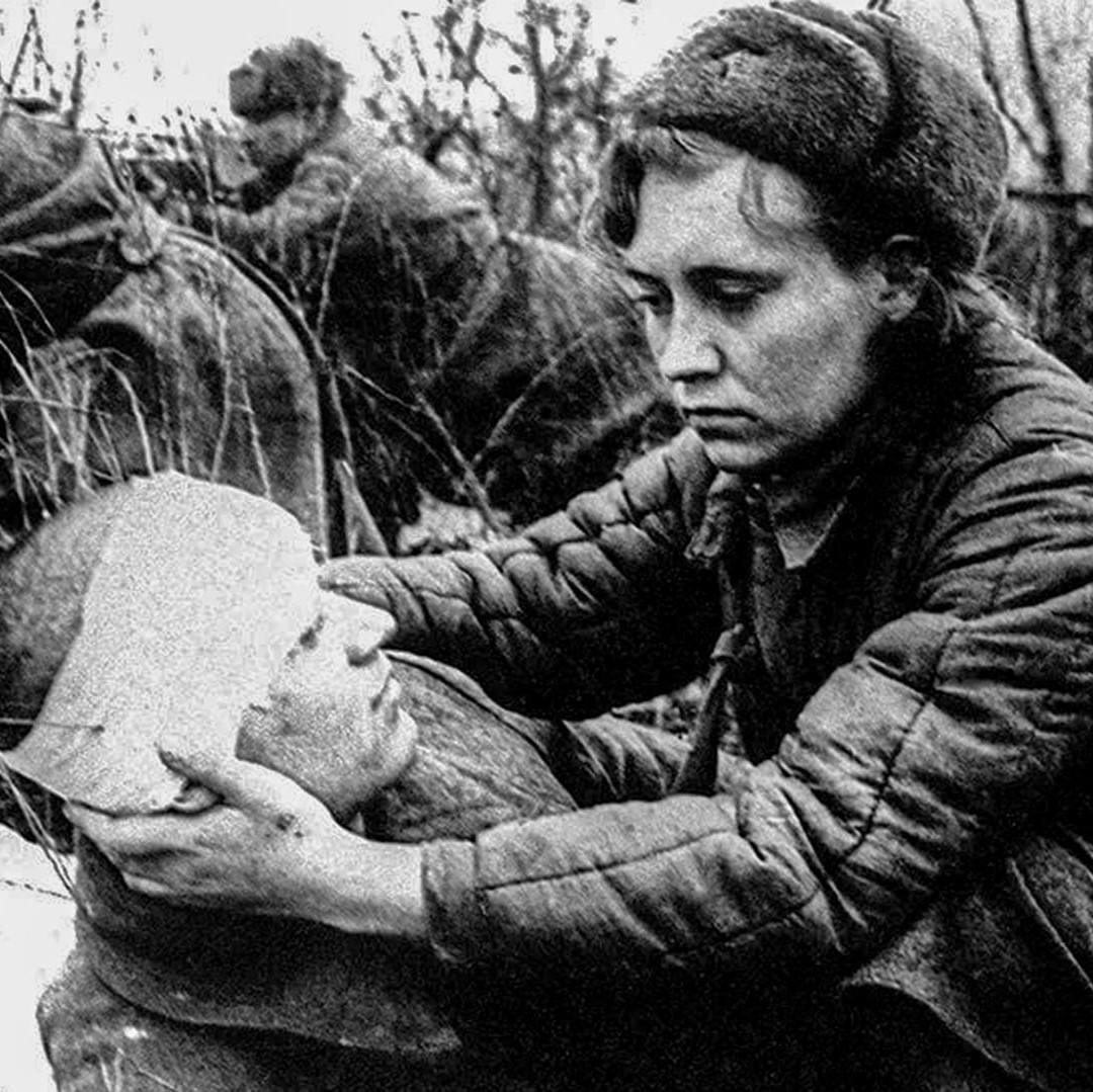 A woman in the WWII russian army tends to a wounded solider