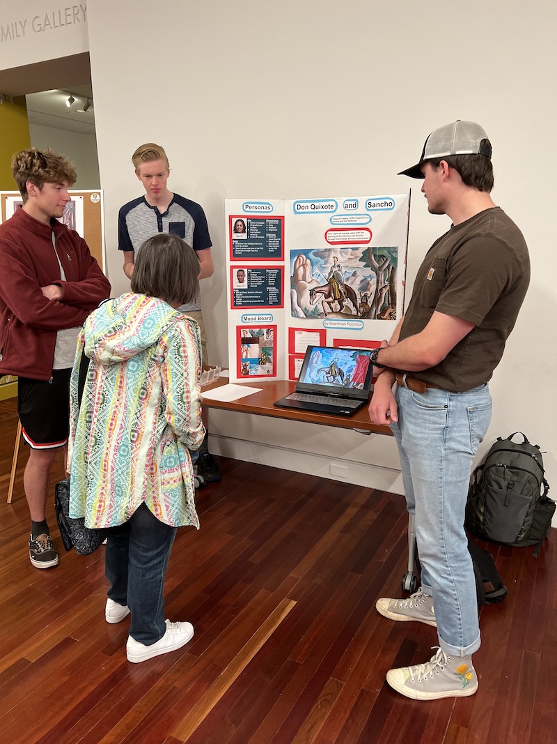 3 students present their findings in a trifold