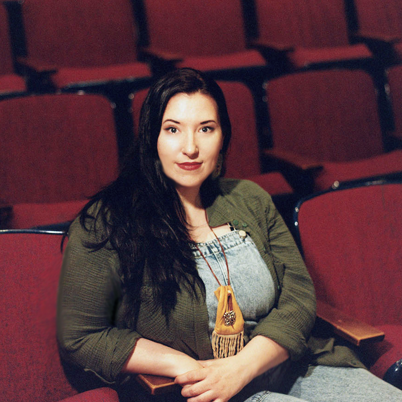 Portrait of Shannon Davis, Assistant Professor of Theatre, smiling against a neutral background.