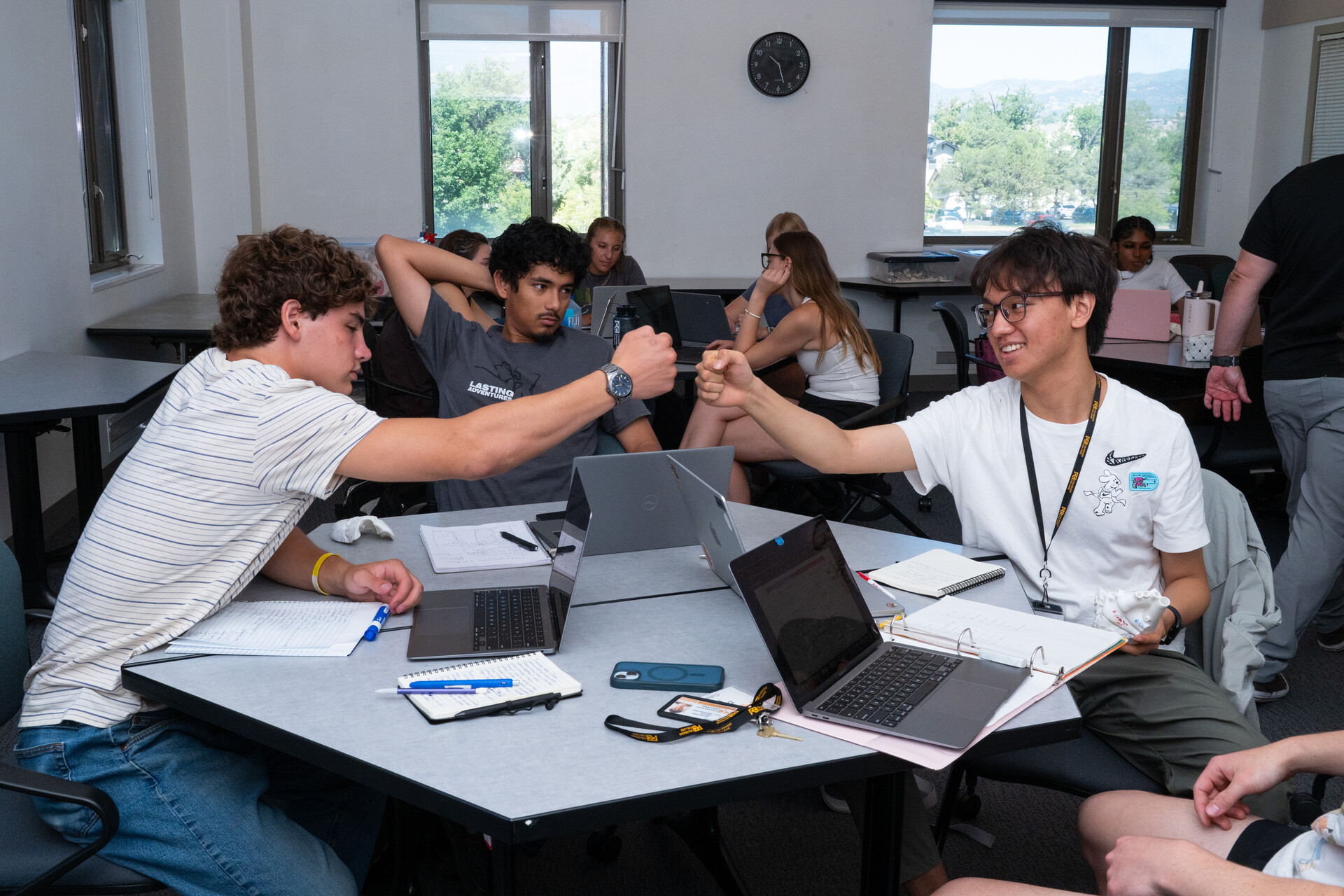 Group of students fist-bumping after an assignment.