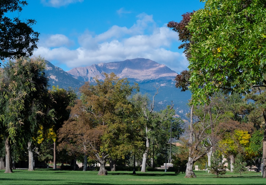 Current CC student leading prospective students on a campus tour. Mountain views in the background.
