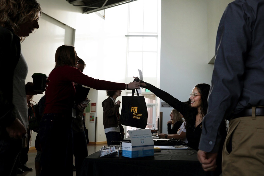 Admission staff checking in a student and giving them a swag bag