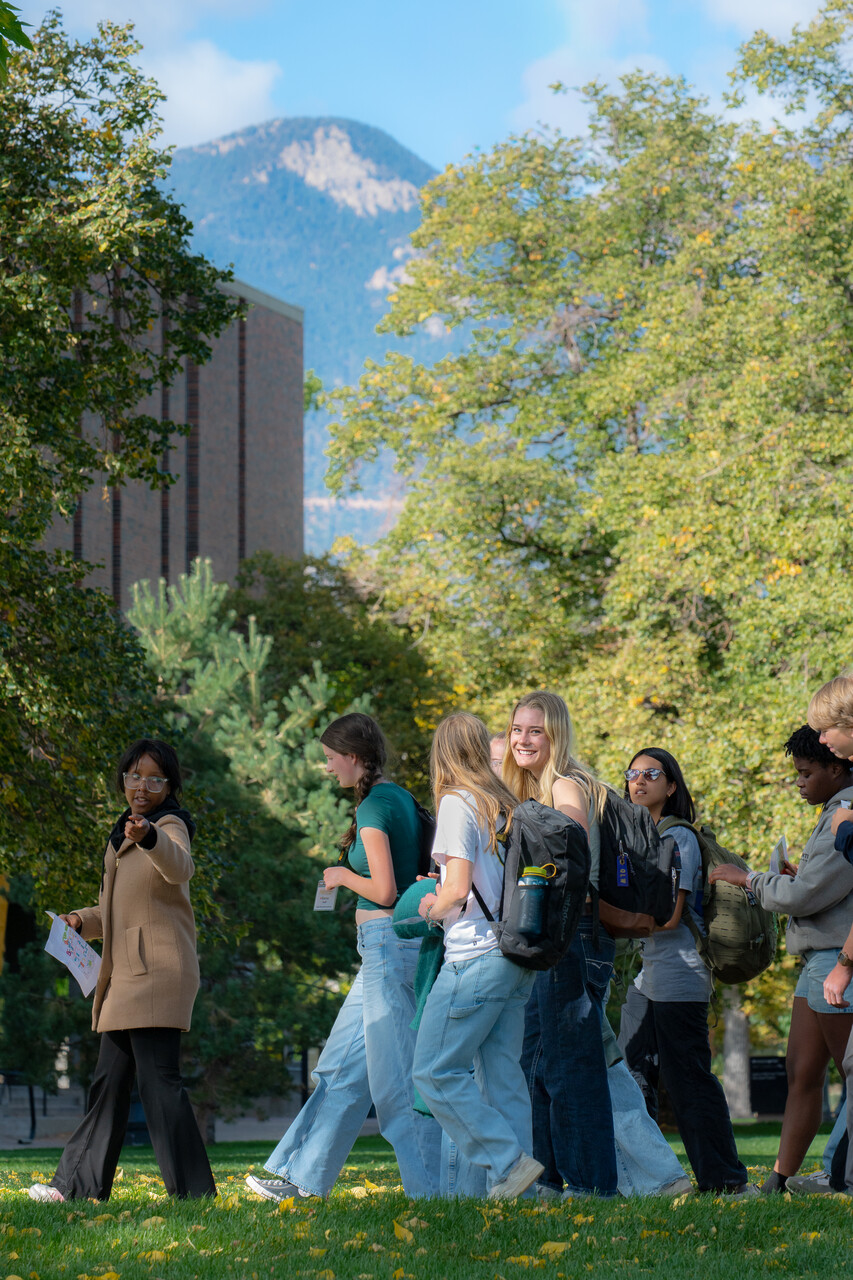 Current CC student leading prospective students on a campus tour. Mountain views in the background.