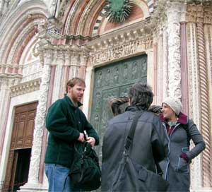 Left, Dan Roose ’04, who accompanied the Renaissance Worlds seminar to Italy, waits at the door to the Duomo in Siena with, from left, Susan Ashley (back to camera), <strong>Emily Auerbach ’05</strong>, and<strong> Joe Schaedler ’05</strong> (behind Ashley).