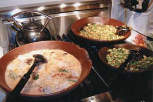 Professor Peter Blasenheim, displaying his culinary skills, treated his half-block class, Understanding and Misunderstanding Latin America, to a delightful Brazilian meal. Muqueca, chockfull of tuna, swordfish, shrimp, and scallops swimming in coconut milk and palm oil, simmers in a panelo de barro, an authentic African cooking vessel he hand-carried from South America. Side dishes included caruru and rice cooked in palm oil, with farinha de mandioca to sprinkle on top.