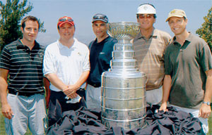 <strong>Noah Clarke 03</strong>, left, and <strong>Marshall Carr 88</strong>, second from left, found themselves in the same foursome at a Dave Taylor Cystic Fibrosis event. Team CC with Carr, a senior vice president at New Line Entertainment, and Clarke, a left wing for the L.A. Kings, finished fourth, but did not take home the Lord Stanleys Cup with which they are pictured.