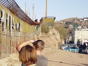  <strong>Eddie Konold 07</strong> and <strong>Stella Copeland 05</strong> watch migrants passing over the wall, entering the U.S. illegally.
