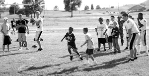 CC football players <strong>Jake Craig 06</strong>, <strong>Drew Millar 08</strong>, and <strong>Marquis Malcom 08</strong> (in striped pants) participated in a skills clinic for children at Fort Carson whose parents were deployed to Iraq. 