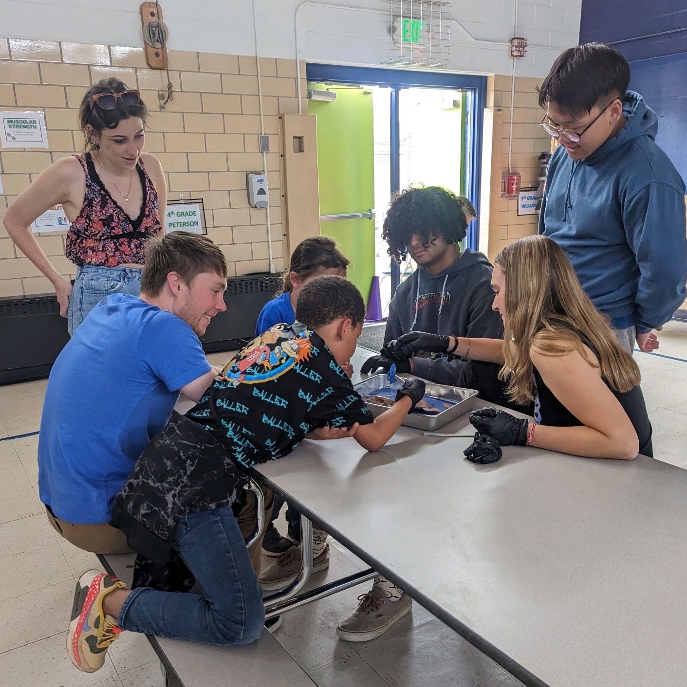  Emma Langas '25, Patrick Hecht '24, Connor Johnson '24, Charlotte Agliata '25, and Sam Lee '23 work with Midland Elementary School students on science experiments during the 2022-2023 school year. Photo submitted by Caitlin Kim '24. 