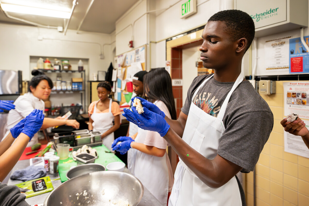 Kuron Reed of Mitchell High makes a seasoned rice ball in CC's Stroud Scholars Program in a cooking class at Bemis Hall as part of a residential experience on 7/13/23. Photo by Lonnie Timmons III / Colorado College.