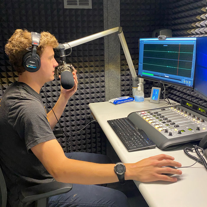 Eli Jaynes ’24 is photographed on Aug. 1, 2022, in the KRCC voice booth where they conduct interviews. Photos submitted by Will Taylor ’23 and Eli Jaynes '24. 