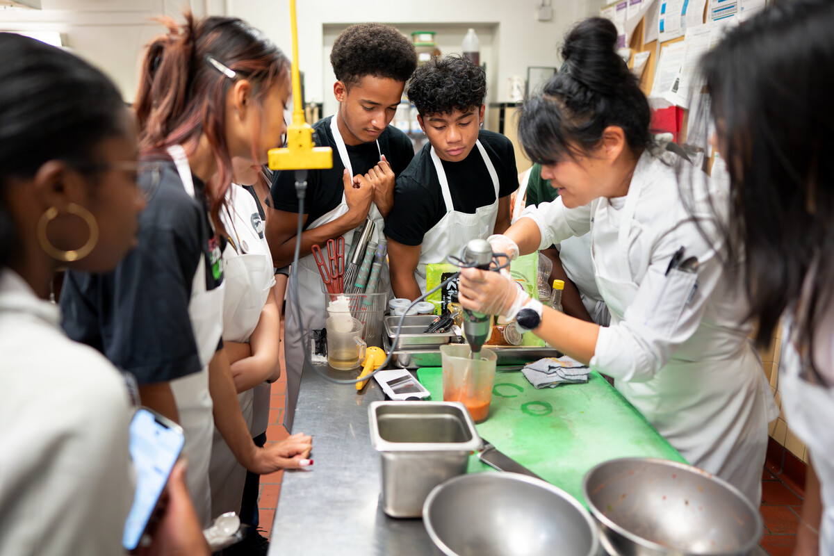 Stroud Scholars watch closely as chef Randi Powell instructs them in a residential experience cooking class at Bemis Hall on 7/13/23. Photo by Lonnie Timmons III / Colorado College.