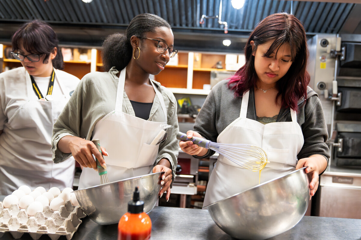 Center, Taylor Flowers of Fountain-Fort Carson High School and Max Alvarez of Odyssey High participate in a CC's Stroud Scholars Program cooking class at Bemis Hall as part of a residential experience on 7/13/23. Photo by Lonnie Timmons III / Colorado College.