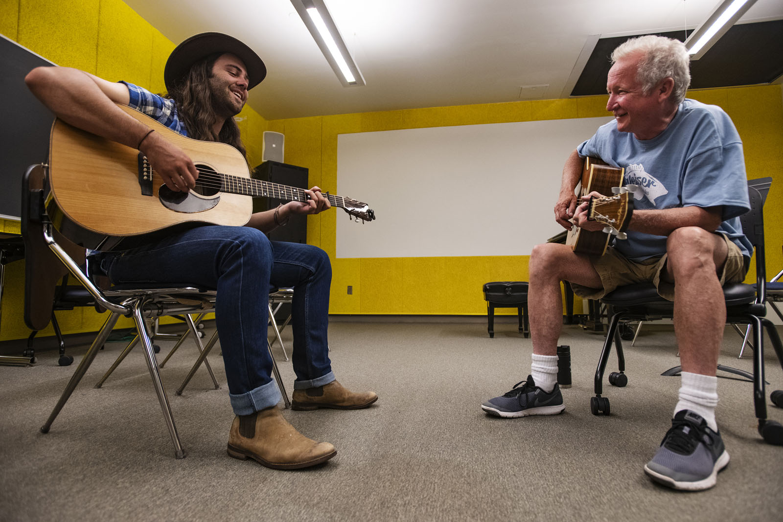Garrett Blackwell ’17 and Nashville artist Jeff White share a laugh as they play together during a one-on-one session at the Bluegrass Workshop in Packard Hall on June 26, 2018.