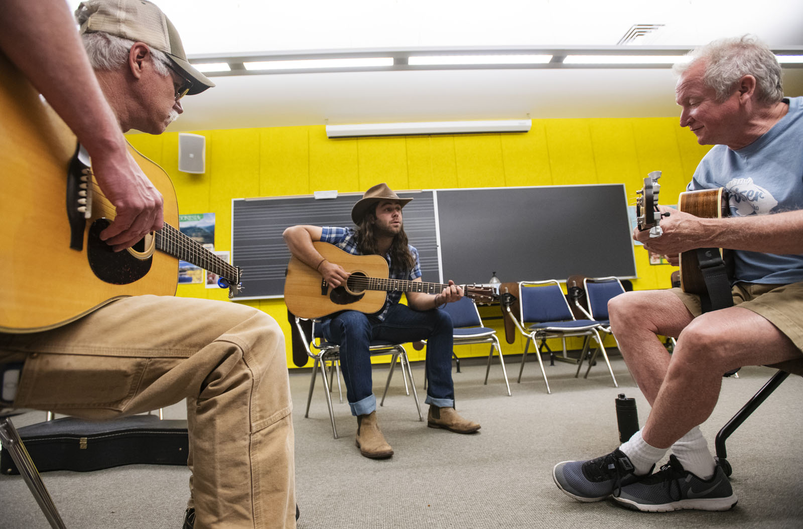 Kenn Lee and Garrett Blackwell ’17 watch their instructor, Nashville guitarist/singer/producer Jeff White, right, play a melody during the Bluegrass Workshop in Packard Hall on June 26, 2018.