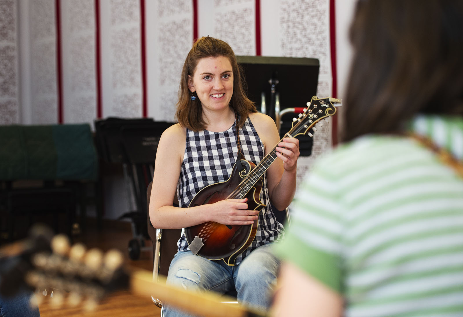 Nicole Pey ’15 holds her mandolin while listening to Grammy-nominated instructor Sierra Hull speak during the Bluegrass Workshop in Packard Hall on June 26, 2018.