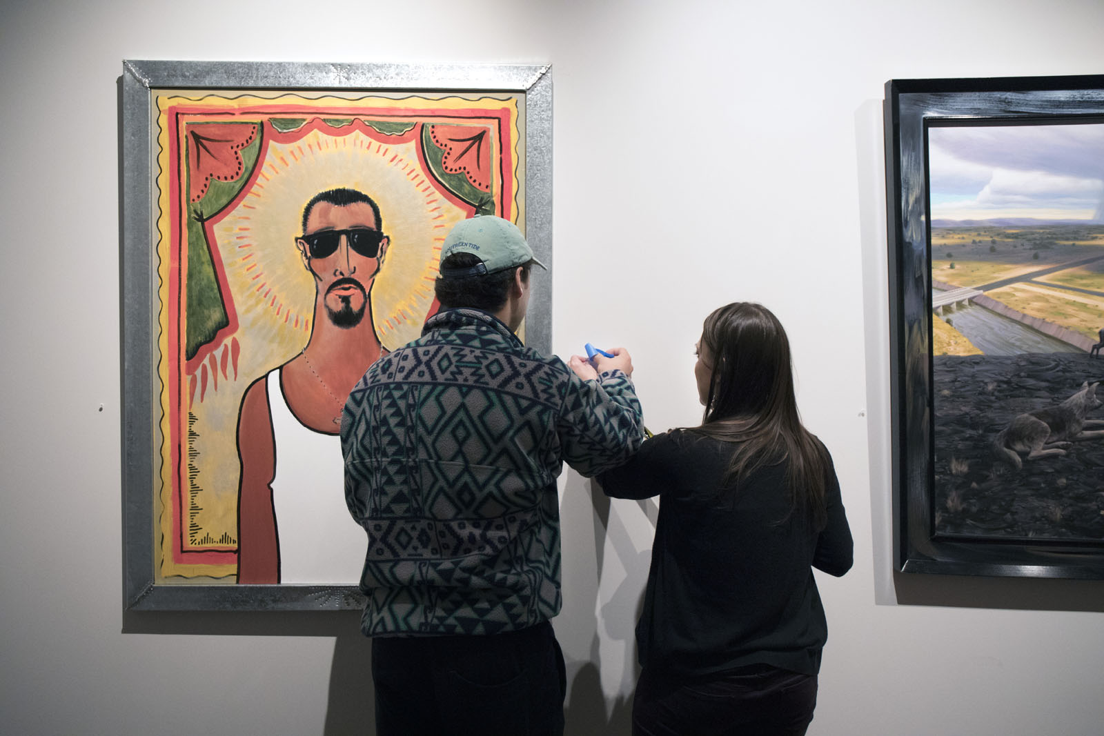 <b>Vaughn Wahlberg '21</b> consults with Visiting Assistant Professor of Art History Victoria Ehrlich before putting up his description of the artwork he selected for the student curated show at the Fine Arts Center.
