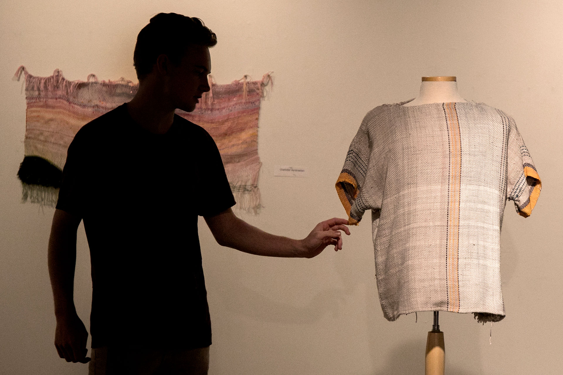 Fiber Arts student Charley Dickey '19 adjusts a shirt he completed for his course and displayed in Coburn Gallery.