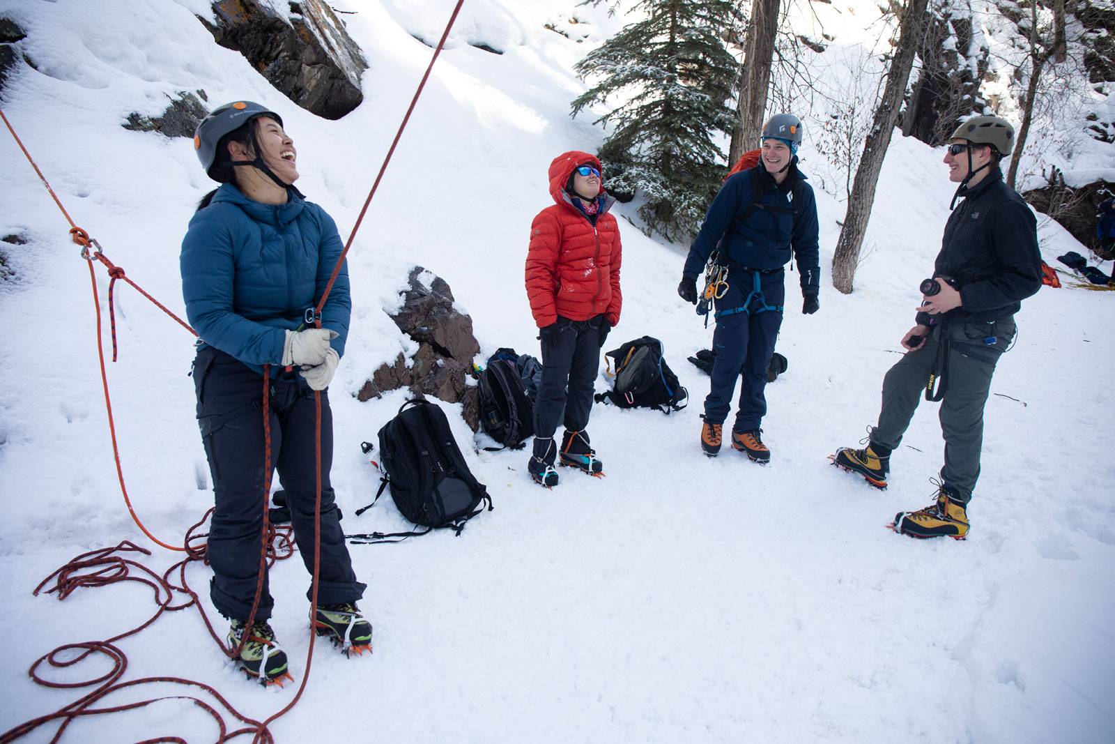 <strong>Saria Sato Bajracharya ’20</strong> laughs as she works as belay while <strong>Kaila Ablao ’21</strong>, David Crye and <strong>James Hanafee ’22</strong> watch and wait for their turns. Outdoor Education took students new to ice climbing to the Ouray Ice Park in Ouray, Colorado during a block break trip. The low-cost trip is designed for students who are new to ice climbing and might not otherwise be able to try out the sport due to the investment required to take lessons and purchase or rent equipment.