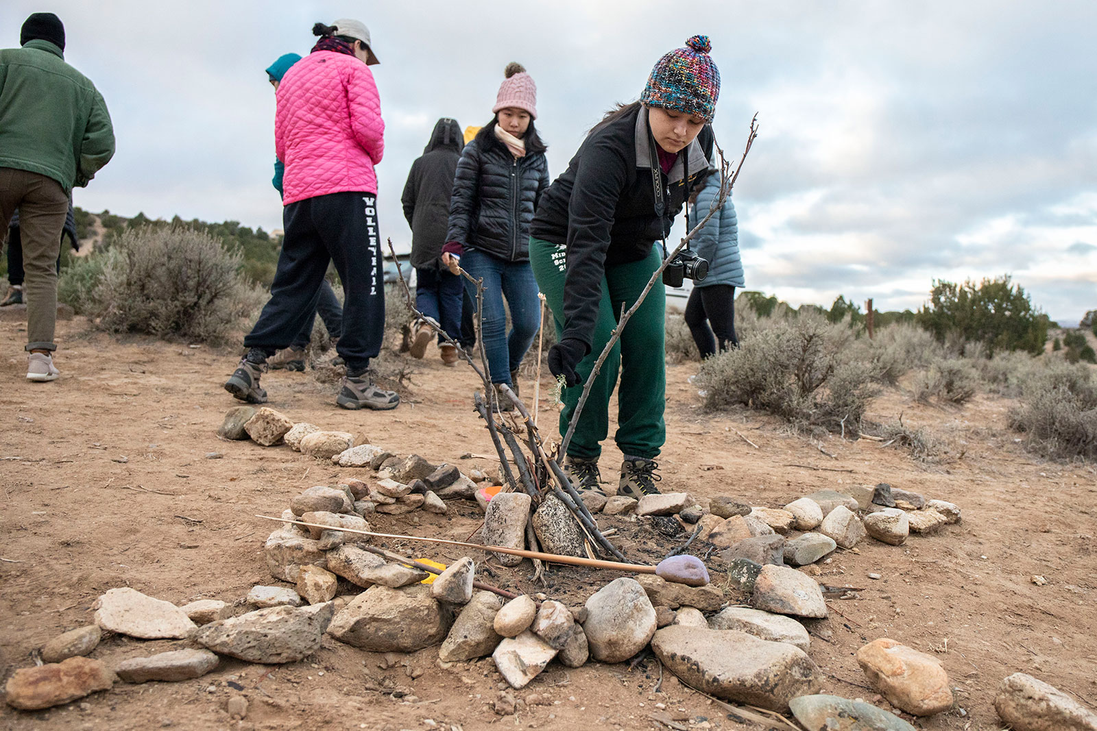 After a sunrise meditation along the Rio Grande Gorge, <strong>Emily Hidalgo ’22</strong> places a twig onto a ceremonial site where fires are lit to indicate the four directions and elements.