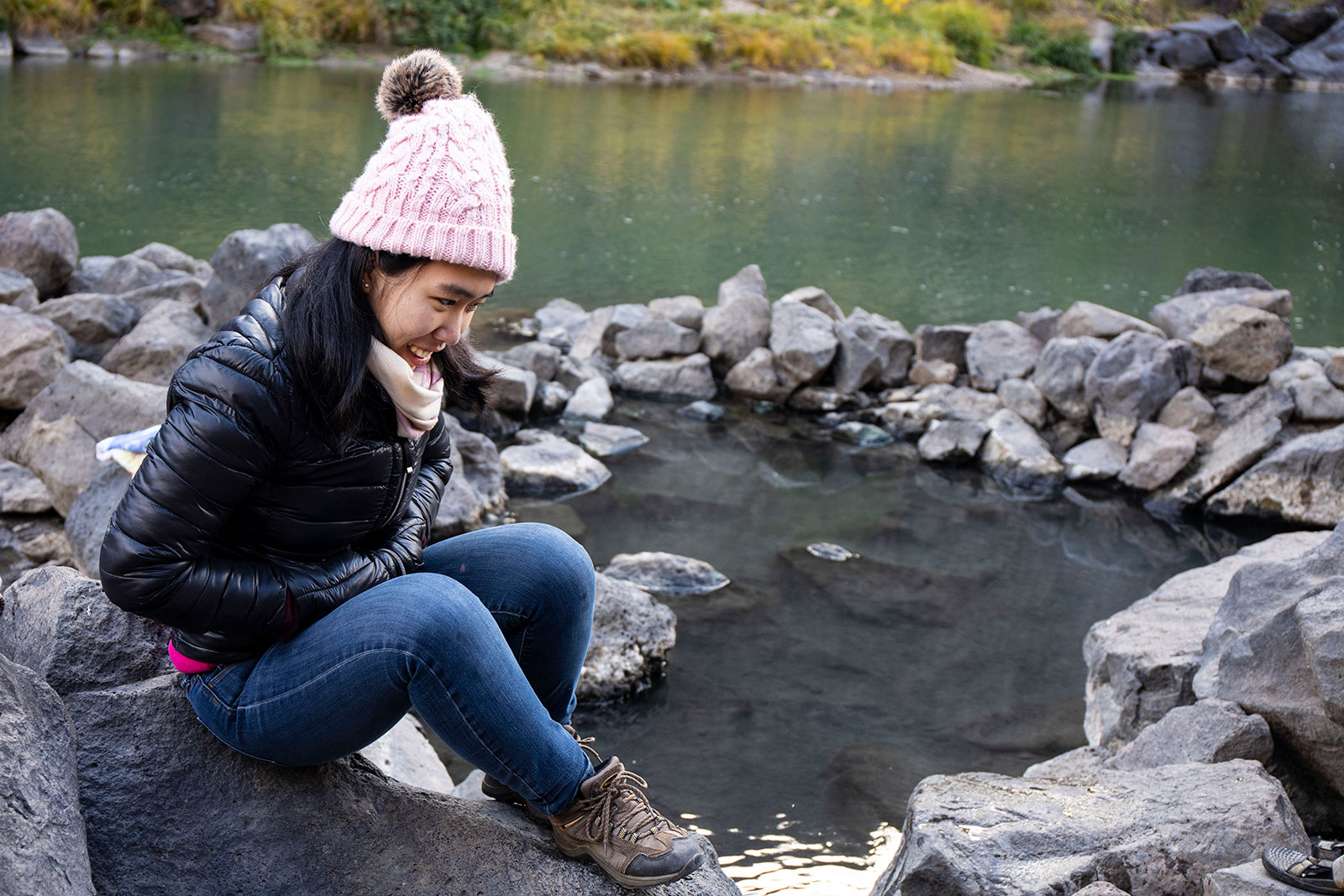 <strong>Jia Mei ’21</strong> sits above a hot spring pool while some of her group soak in the pools alongside the Rio Grande River.
