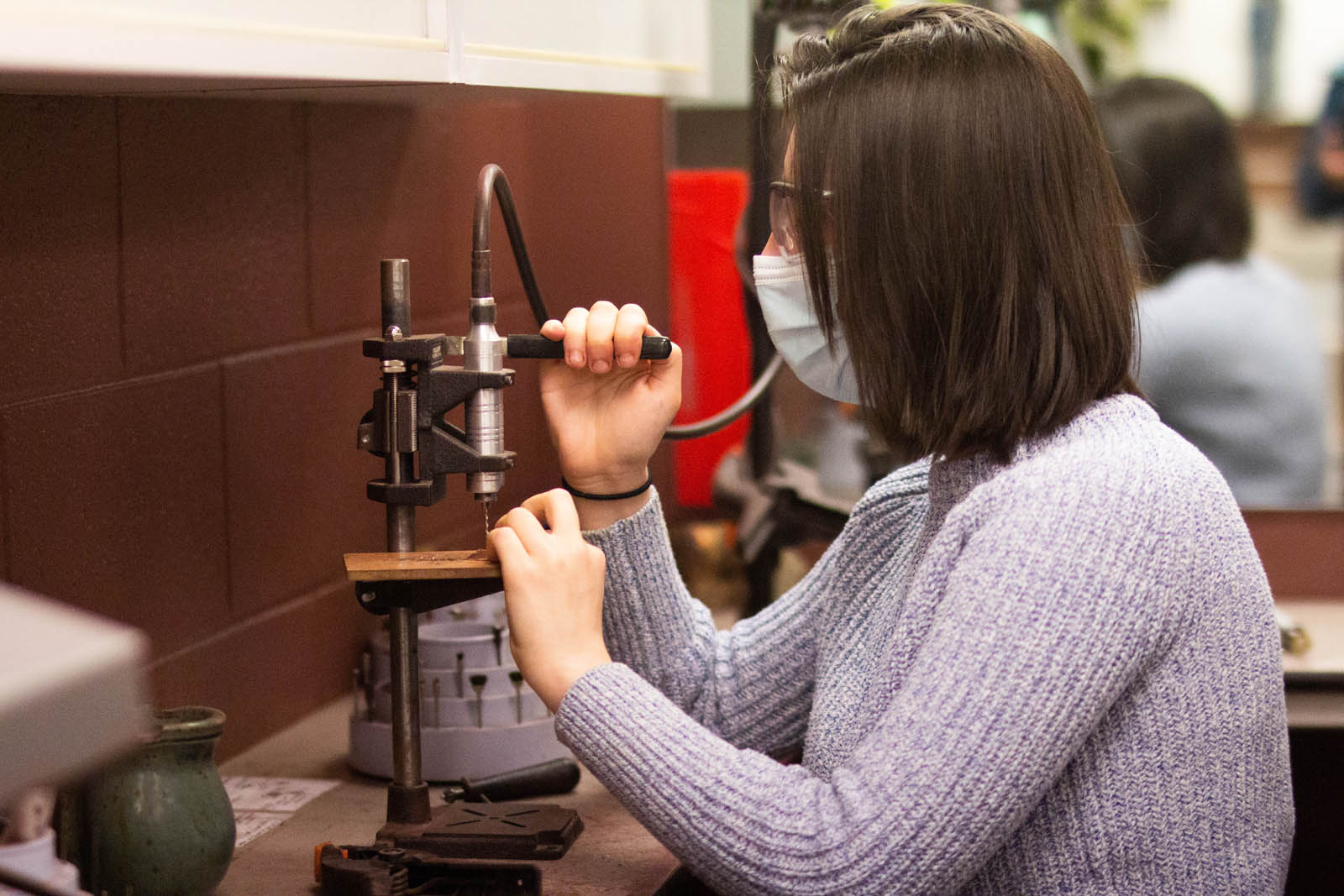 <strong>Emily Miner '21</strong> operates a press during a jewelry class taught by <strong>Miles Marshall ’21</strong>. Photo by <strong>John Le ’24</strong>