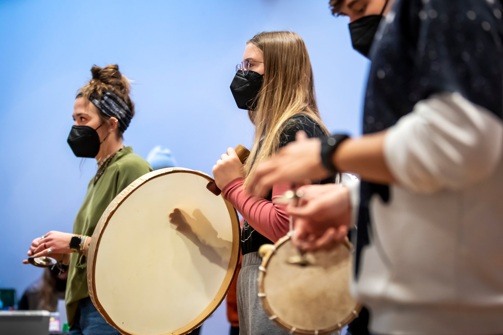 From left, Auna McConnaughey ’24 plays finger cymbals (behind larger drum) and Mira Giles-Puhahl ’25 plays large hand drum (with shadow of hand). Photo by Lonnie Timmons III