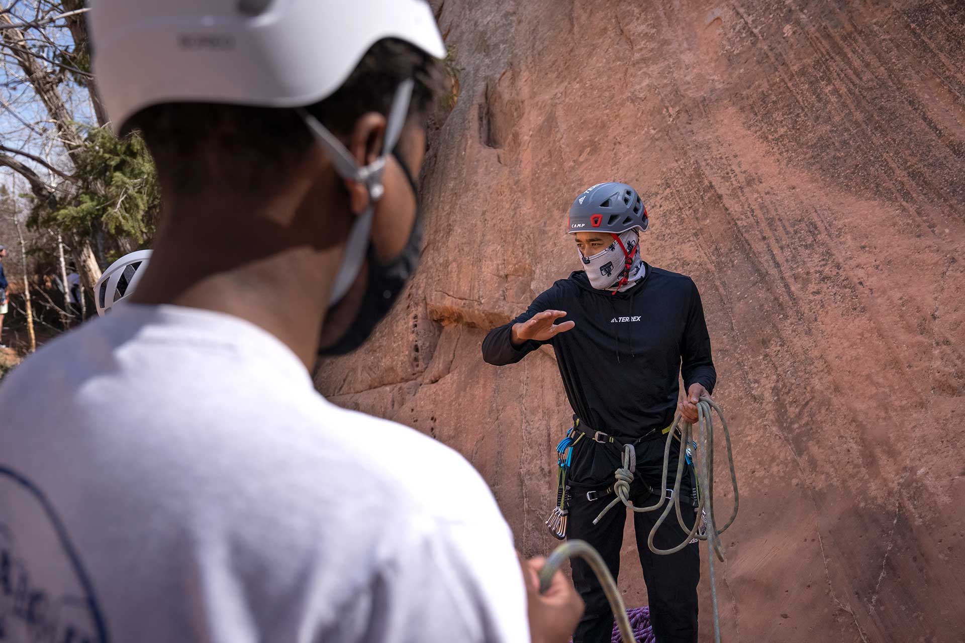 Devon Derby, a rock climbing instructor and marketing manager for Adidas Outdoors, runs through safety information with the group before beginning his climb. 