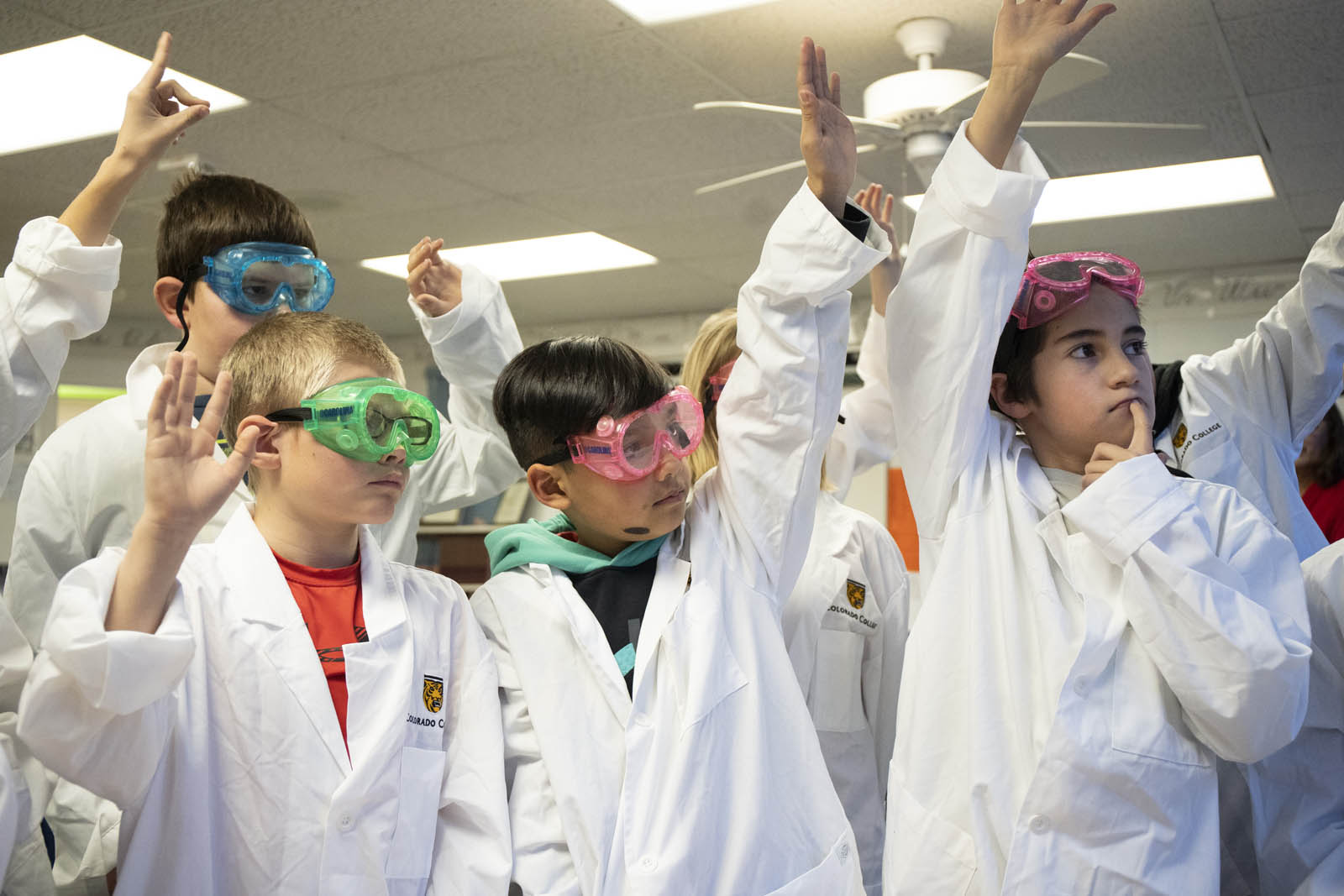 Fifth-graders at La Veta Elementary School raise their hands to make a hypothesis about the class experiment during a lesson taught by CC students. Photo by Jennifer Coombes.
