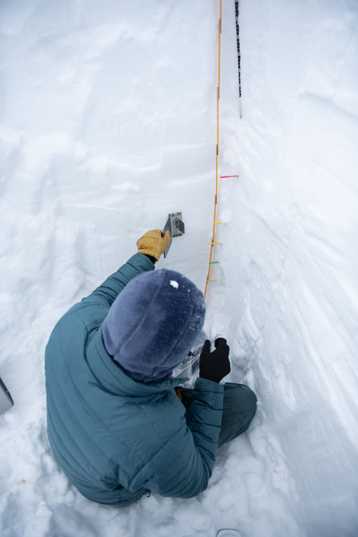 Adam Keim '23 is pictured using a density cutter to extract snow from the snowpack. This sample was then weighed, and the weight was later  used to calculate snow density, snow water equivalent (SWE), and snow liquid ratio (SLR), which are three important metrics used in snow science. Photo by Matthew Silverman '23. 