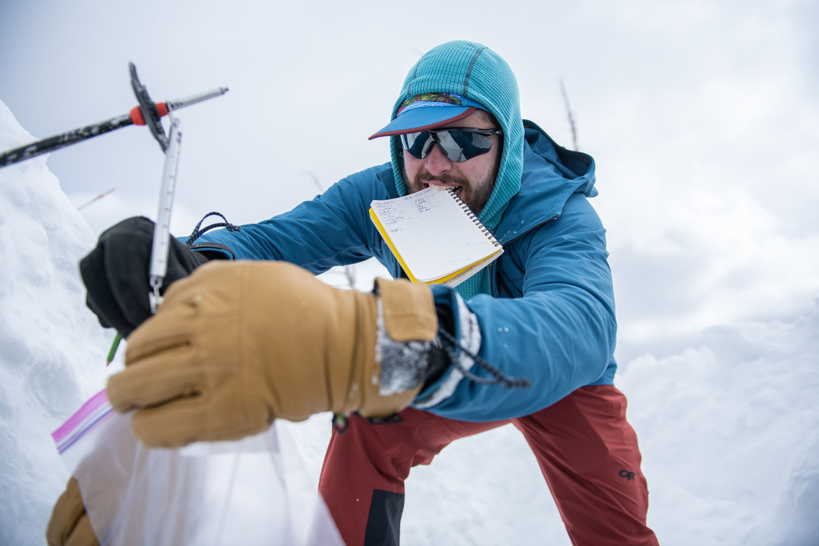 Reuben Alter '24 is pictured weighing a snowpack sample. This weight was later  used to calculate snow density, snow water equivalent (SWE), and snow liquid ratio (SLR), which are three important metrics used in snow science. Photo by Matthew Silverman '23. 