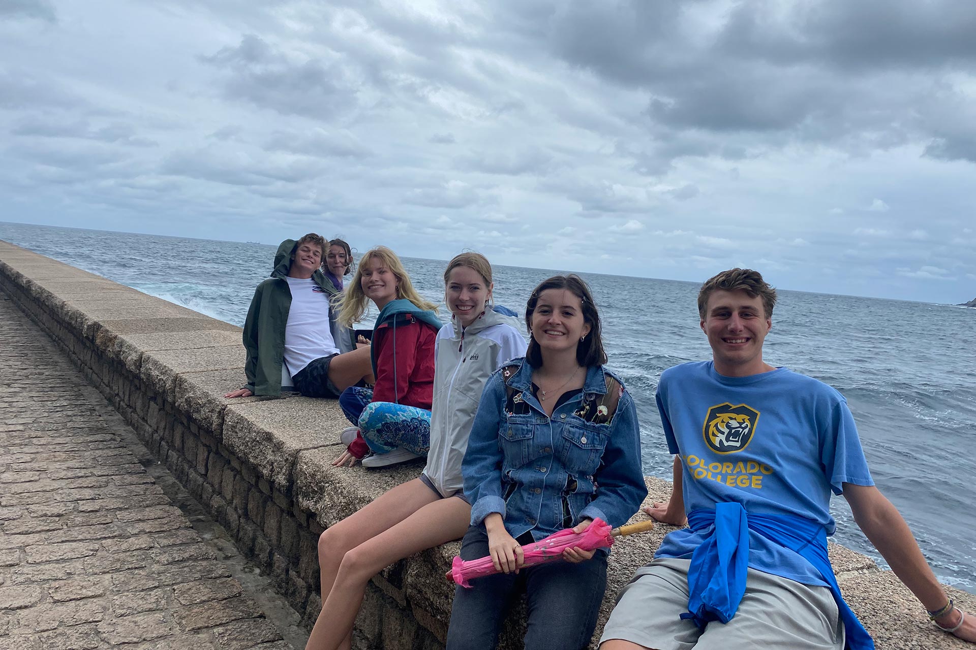 Students sit perched by the Atlantic Ocean. 