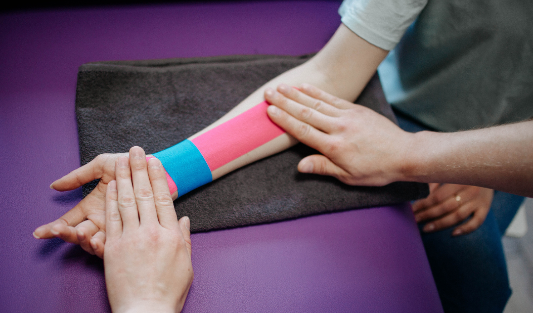Image of an application of kinesiology tape to a person's arm.