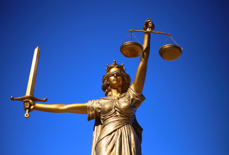 Image of "Lady Justice" blindfolded with a sword and a scale.