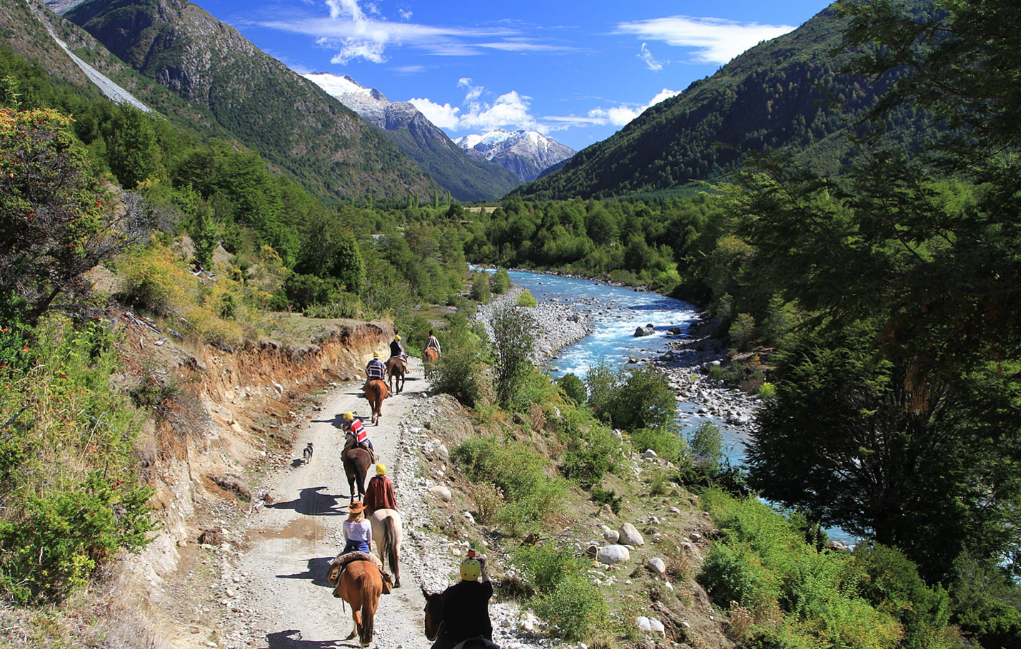 A group riding horses next to the Futaleufú River