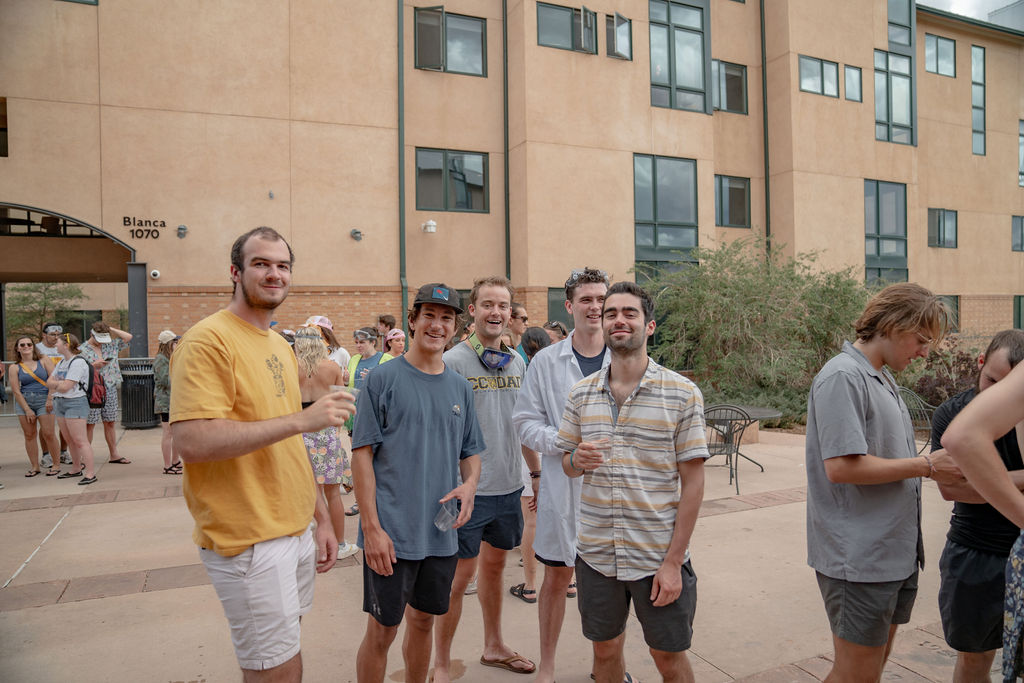 A group of students smiling and posing for the camera while in line for food at the senior BBQ <span class="cc-gallery-credit">[Gray Filter Photography]</span>