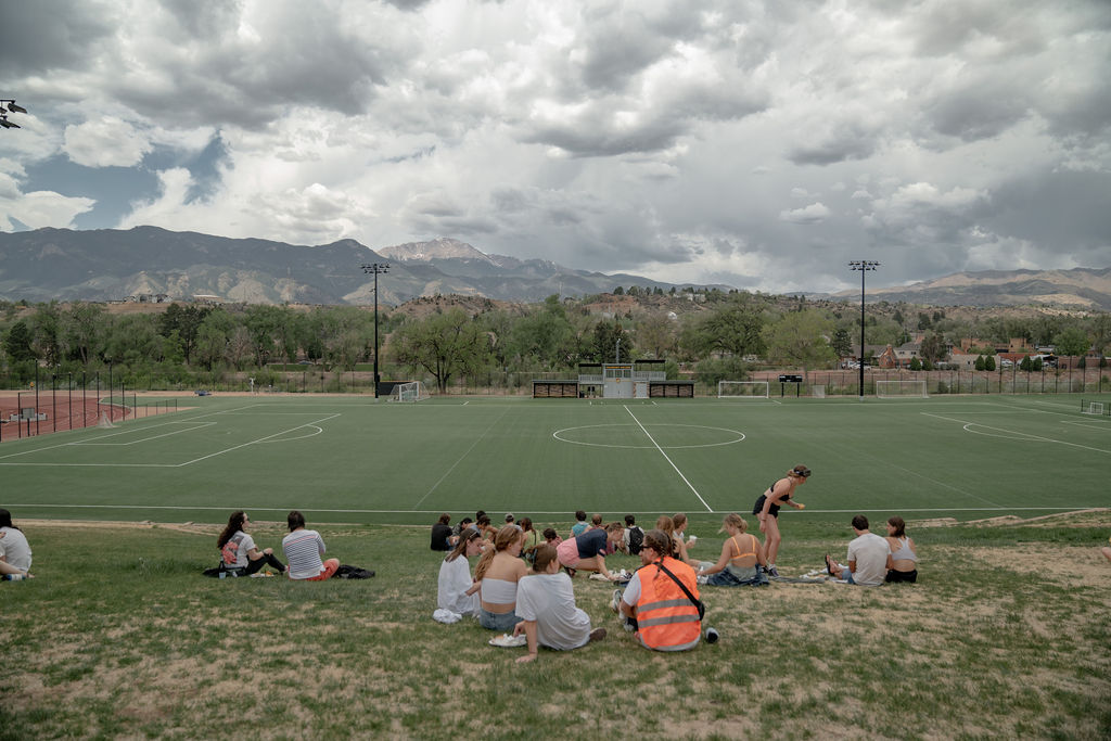 Groups of students sitting on Preserve Hill facing the mountains <span class="cc-gallery-credit">[Gray Filter Photography]</span>
