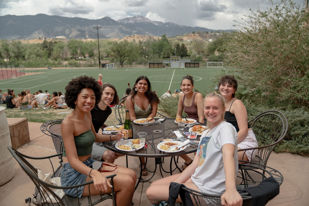 A group of students eating at a table outside at the senior BBQ <span class="cc-gallery-credit">[Gray Filter Photography]</span>