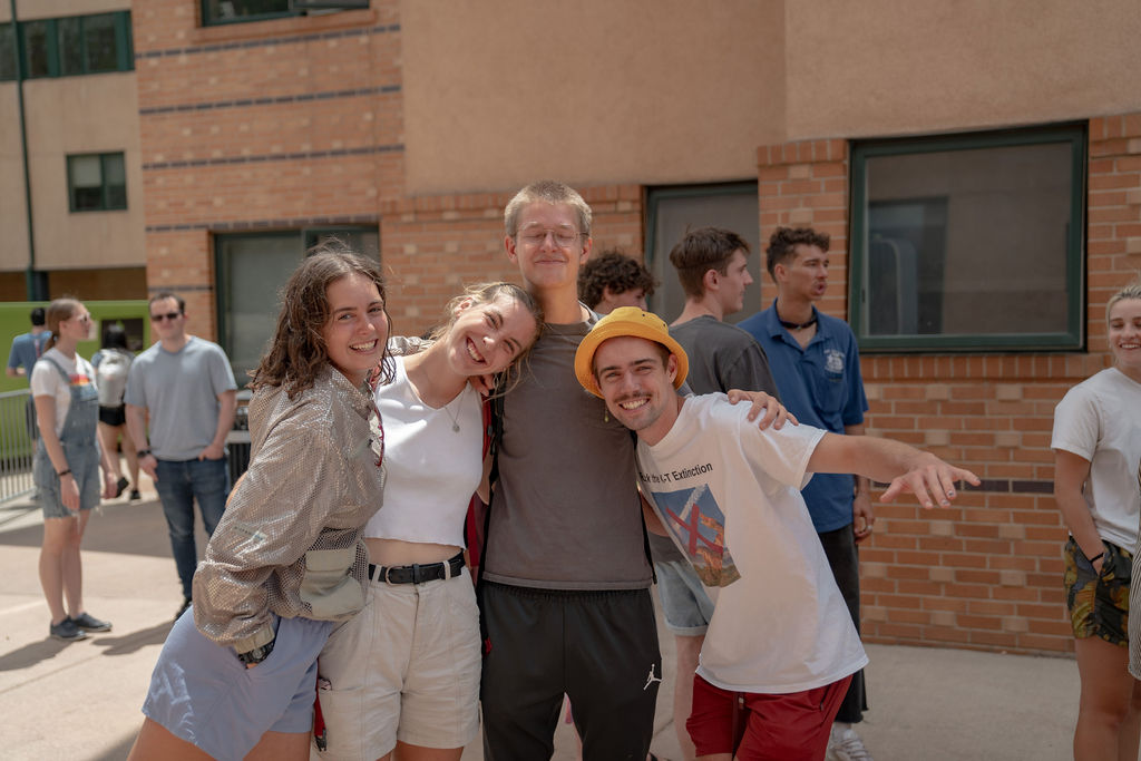 A group of students smiling and posing for the camera while in line for food at the senior BBQ <span class="cc-gallery-credit">[Gray Filter Photography]</span>