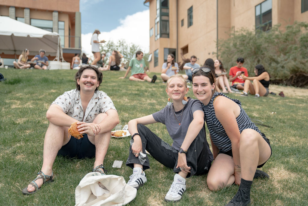 A group of students smiling while sitting on Preserve Hill <span class="cc-gallery-credit">[Gray Filter Photography]</span>