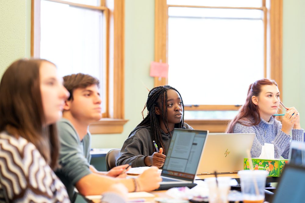 Students listen and take notes in a classroom.