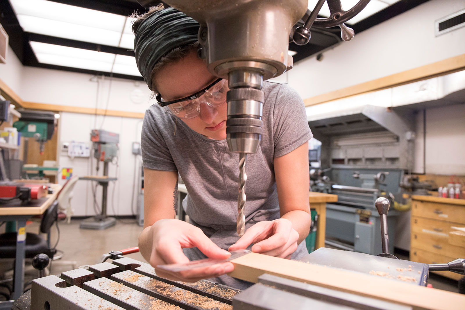 Working in the machine shop in Olin Hall, Alana Aamodt creates the wooden pieces needed to demonstrate her Big Idea rube goldberg machine for team Momentix. <span class="cc-gallery-credit"></span>