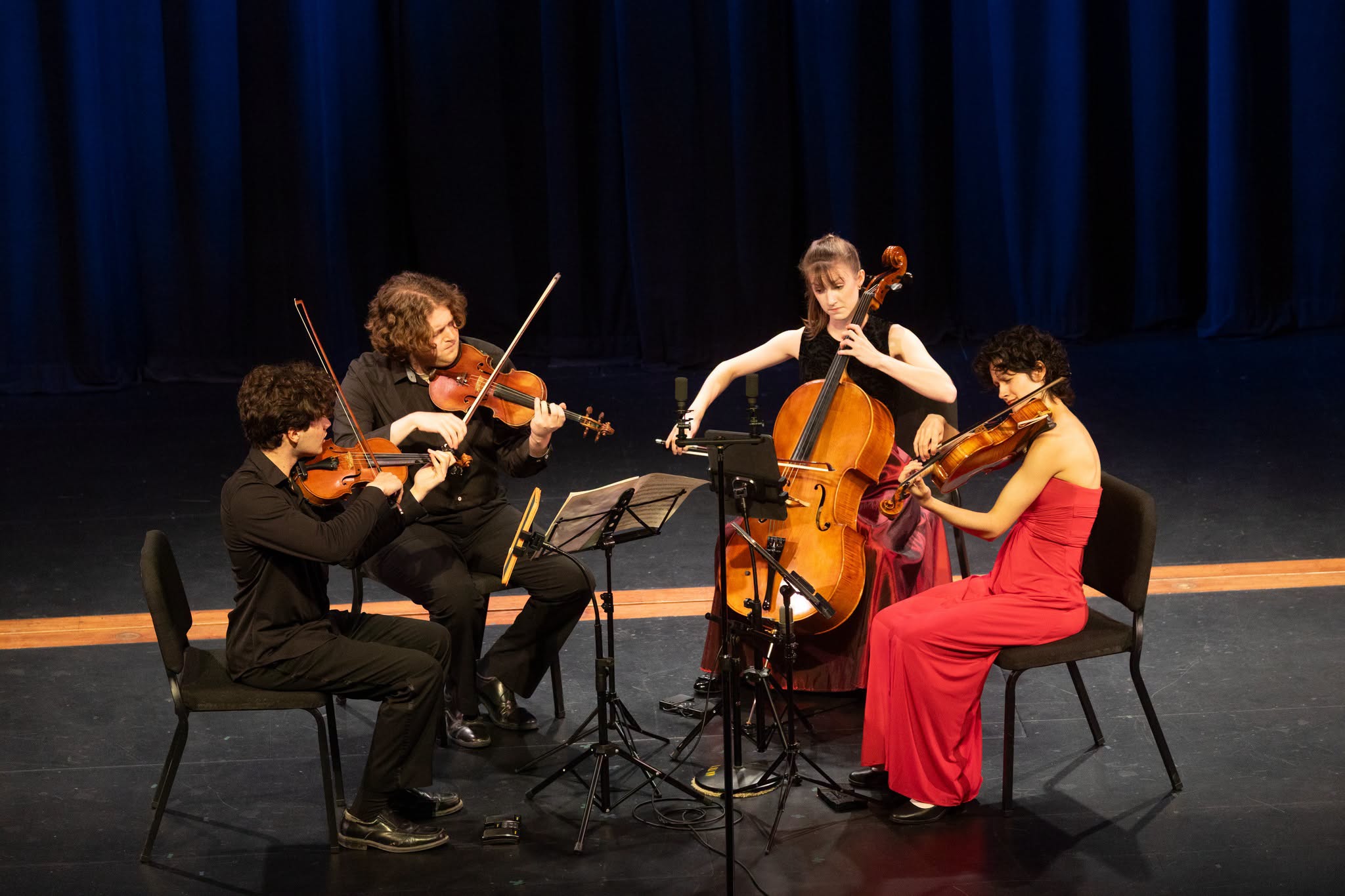 Four young people playing on stage in a string quartet